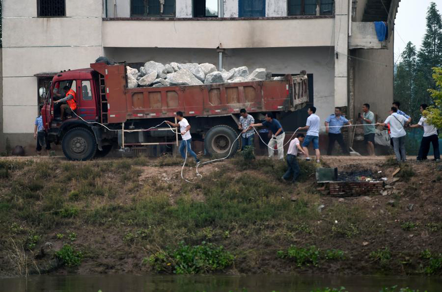 Socorristas arriscam a vida utilizando caminh?es para bloquear inunda??es