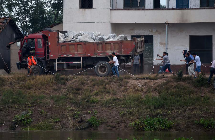 Socorristas arriscam a vida utilizando caminh?es para bloquear inunda??es