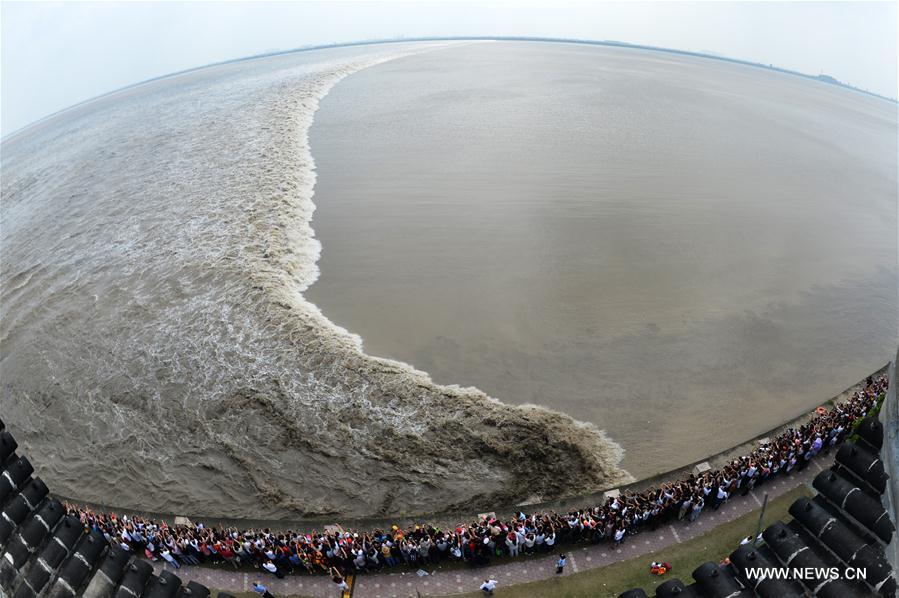 Visitantes observam subida da maré do Rio Qiantang
