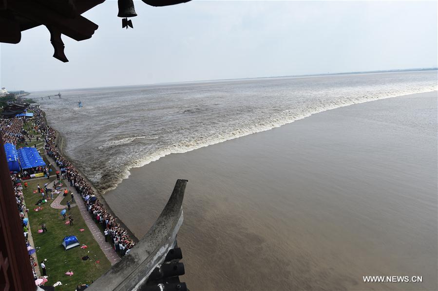 Visitantes observam subida da maré do Rio Qiantang