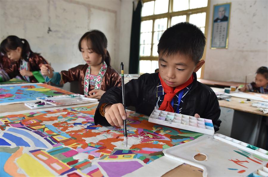 Crian?as fazem pinturas de agricultores tradicionais da etnia Dong no sul da China