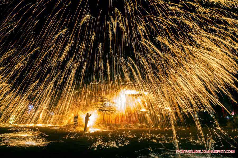 Excutantes espalham ferro derretido quente para simular a exposi??o dos fogos de artifício em Neihuang
