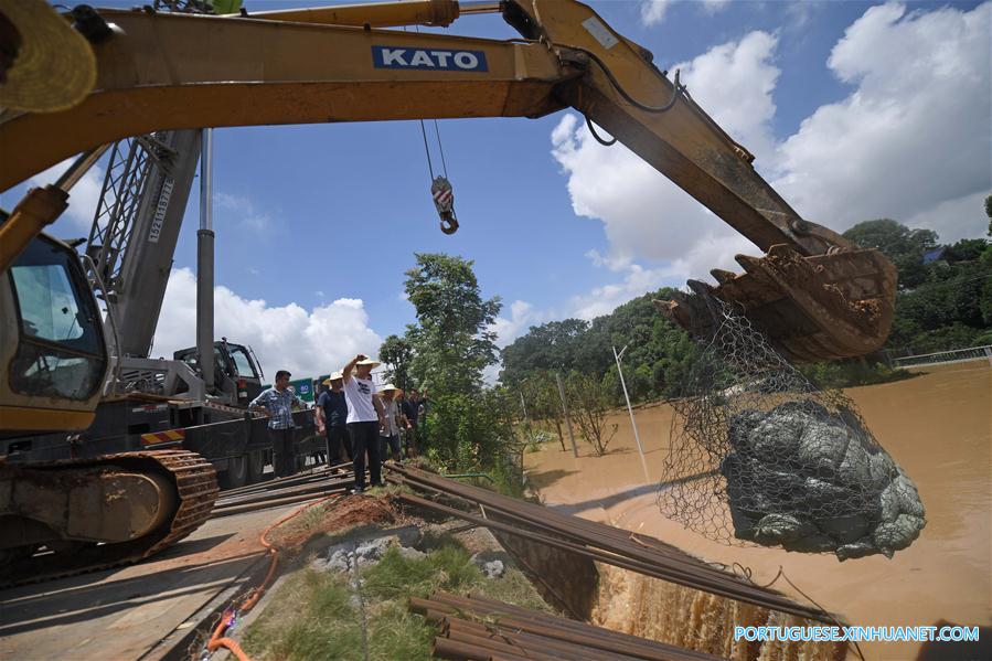 Caminh?o reboque é utilizado para bloquear passagem de água em regi?o alagada em Changsha
