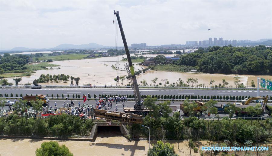 Caminh?o reboque é utilizado para bloquear passagem de água em regi?o alagada em Changsha