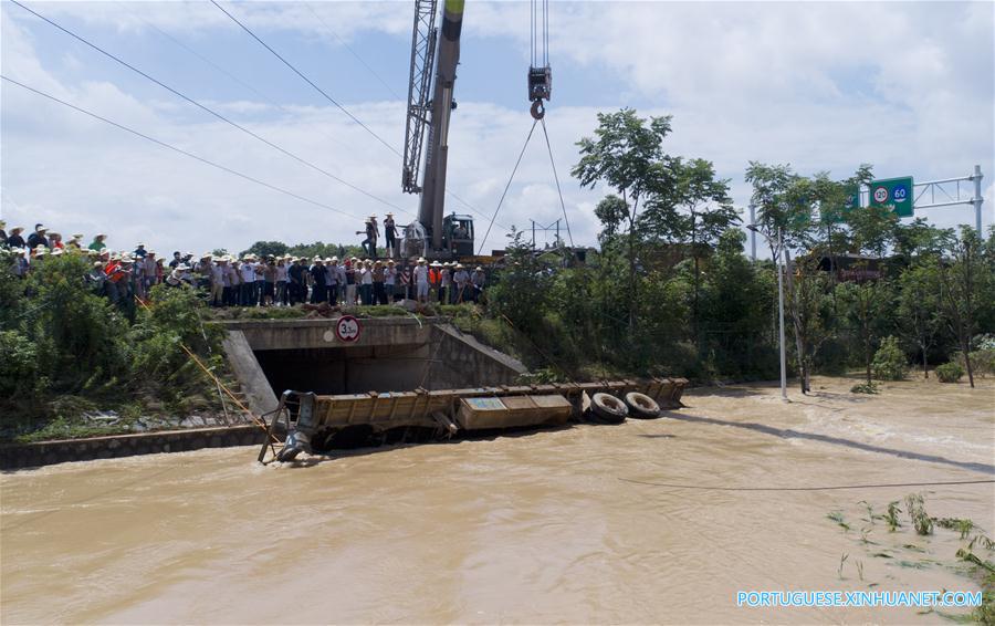 Caminh?o reboque é utilizado para bloquear passagem de água em regi?o alagada em Changsha
