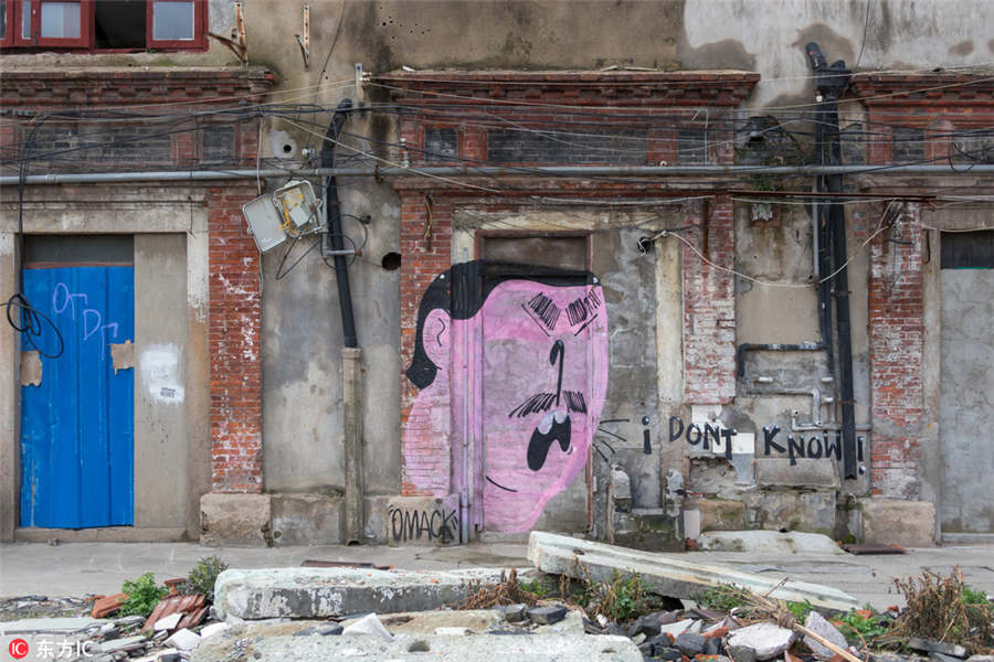 Graffitis d?o nova vida a local em demoli??o em Shanghai