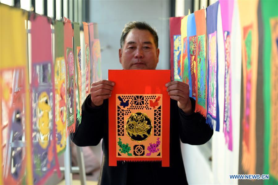 Shandong: Artes?os preparam trabalhos de recorte de papel para receber o Festival da Primavera