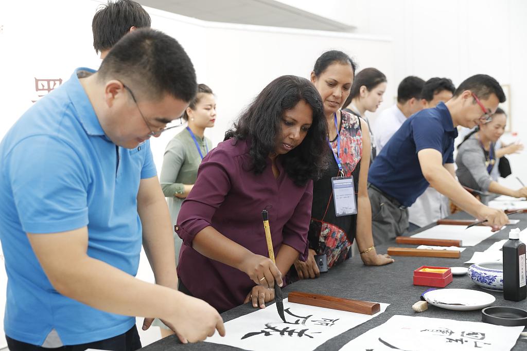 Autoridades de educa??o estrangeira tentam caligrafia em Beijing