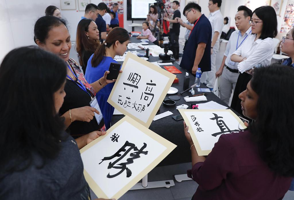 Autoridades de educa??o estrangeira tentam caligrafia em Beijing