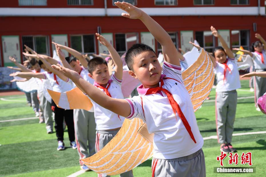 China: alunos de escola primária usam “asa de um metro” para manter distanciamento

