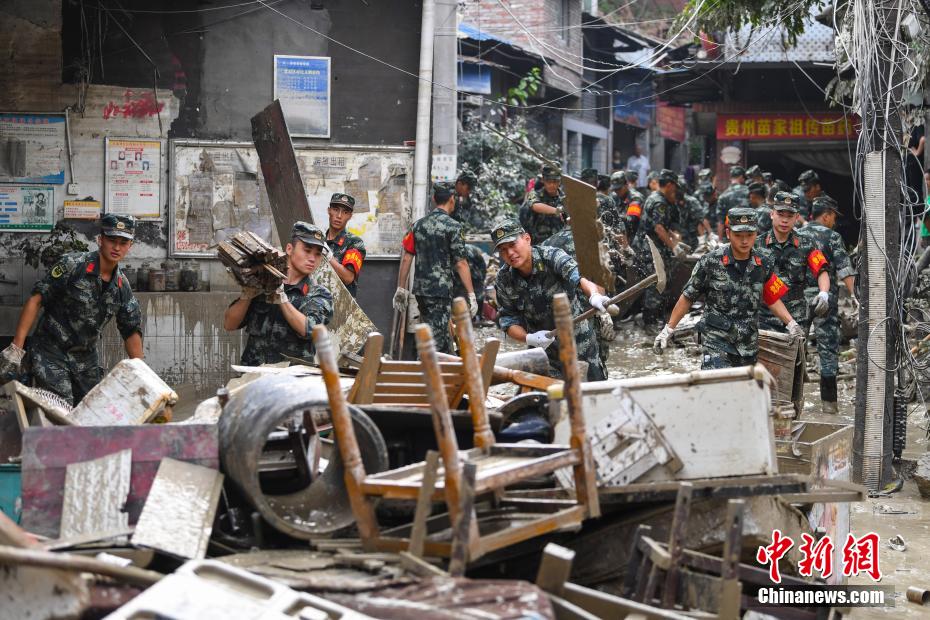Oficiais e soldados limpam lama depois da inunda??o em Chongqing