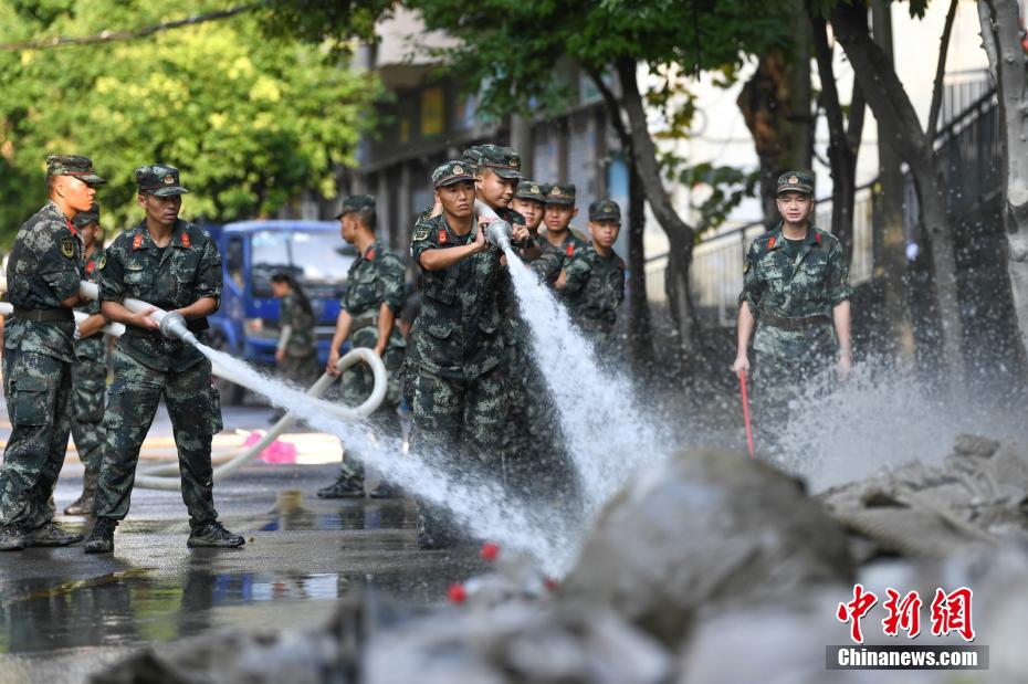 Oficiais e soldados limpam lama depois da inunda??o em Chongqing