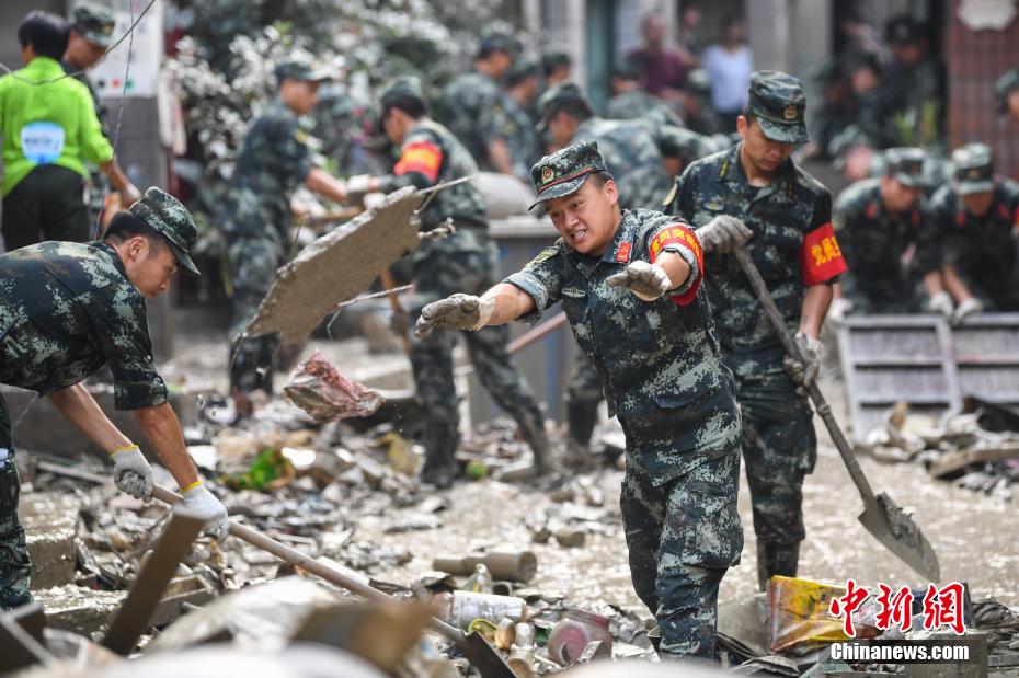 Oficiais e soldados limpam lama depois da inunda??o em Chongqing