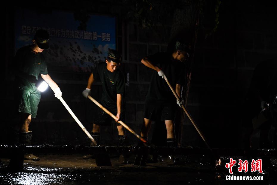 Oficiais e soldados limpam lama depois da inunda??o em Chongqing