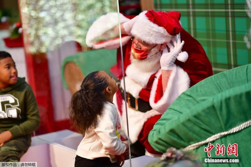 Papai Noel interage com crian?as por vidro durante pandemia