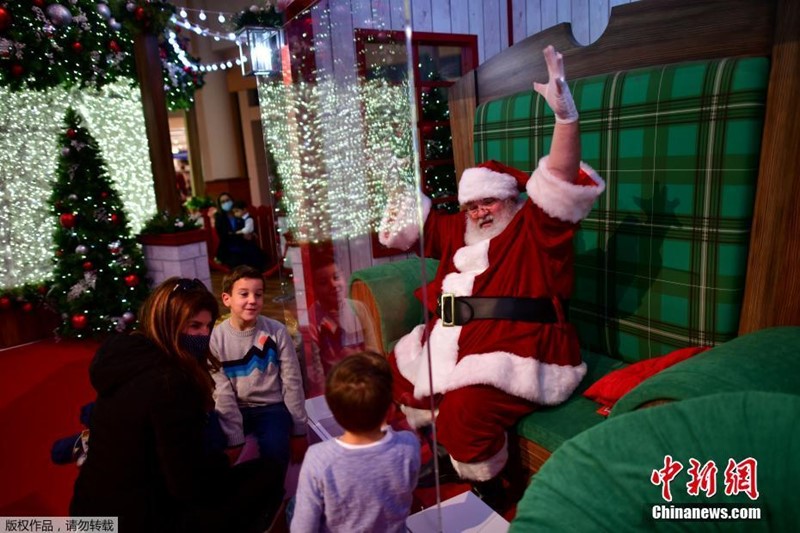 Papai Noel interage com crian?as por vidro durante pandemia