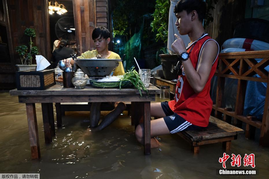 Tailandia: clientes comem em restaurante inundado