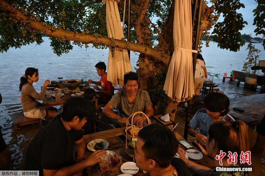 Tailandia: clientes comem em restaurante inundado