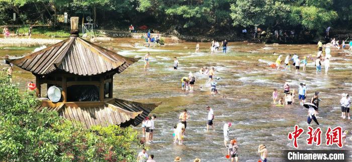 Fujian: turistas desfrutam da frescura do ver?o nas pra?as de água