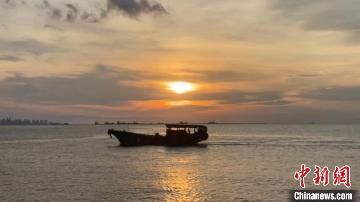 Haikou: bela paisagem do p?r do sol na Baía atrai cidad?os e turistas
