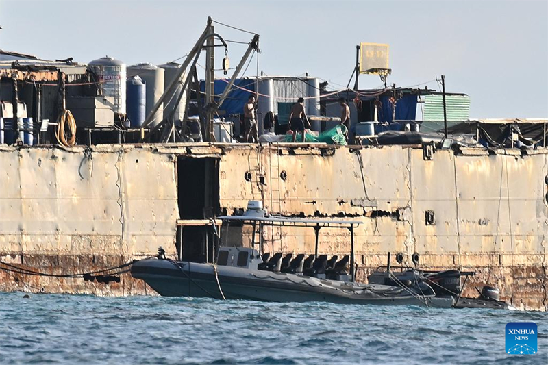 Tripula??o da marinha filipina em navio encalhado ilegalmente destrói redes de pesca chinesas