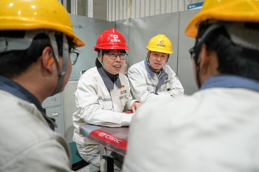 Sun Jingnan (2o E) conversa com colegas numa oficina da CRRC Nanjing Puzhen Co., Ltd. em Nanjing, província de Jiangsu, leste da China, em 20 de fevereiro de 2025. (Foto: Li Bo/Xinhua)